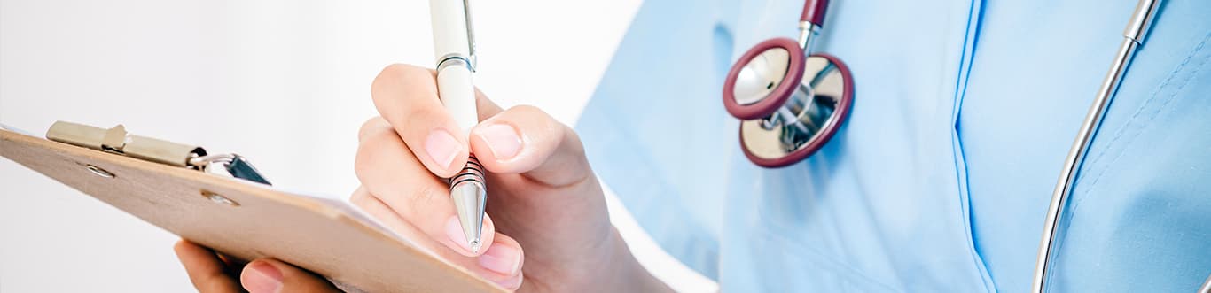 Nurse with stethescope writing on clipboard